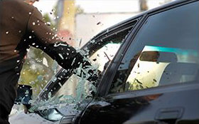 man breaks car window